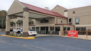 A Red Roof Inn with a covered parking area and a two-story building. - Red Roof Inn Moss Point (Moss Point)