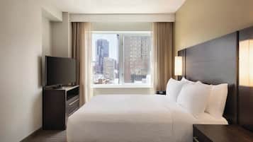 Ropa de cama hipoalergénica y caja de seguridad en la habitación