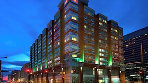 A multi-story hotel with a modern design, featuring a prominent sign at the top and multiple balconies.