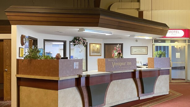 A reception desk with a sign reading "Welcome to Voyageur Inn & Conference Center". - Voyageur Inn and Conference Center (Reedsburg)