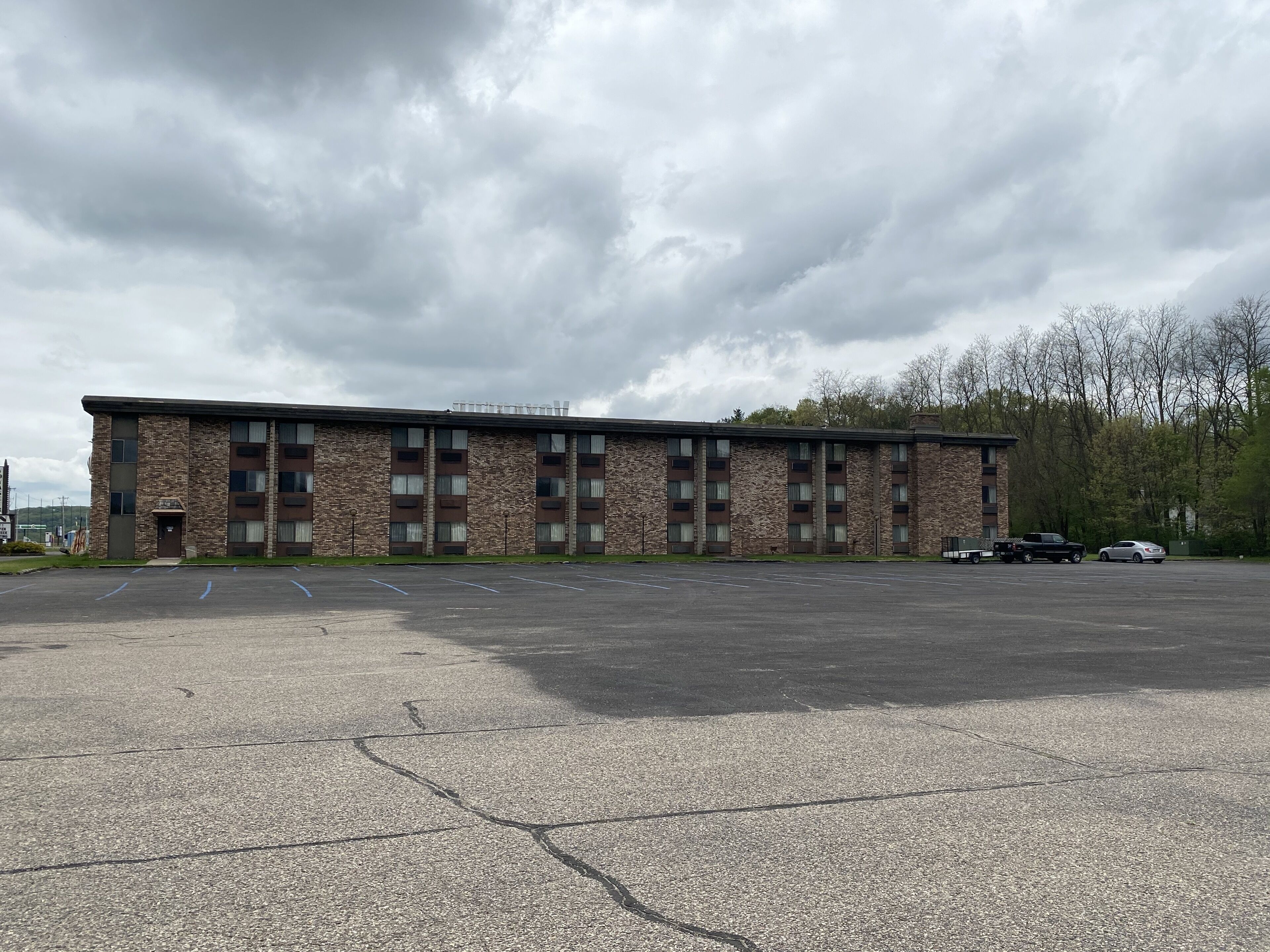 A multi-story building with a parking lot in front.