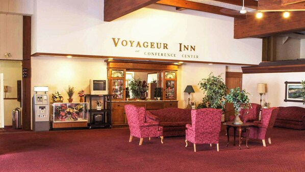 A lobby with a reception desk, a conference center sign, and seating area.