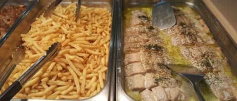 Un bufé con papas fritas y un plato de carne y verduras.