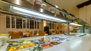 A buffet area with various food options and seating arrangements. - Hotel Don Juan (Granada)