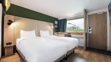 Una habitación de hotel con una cama grande, un escritorio y una puerta.