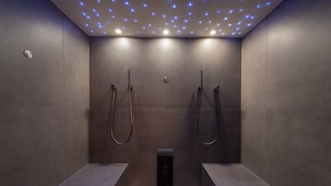 A modern, dimly lit shower area with recessed lighting and a control panel. - Hotel Chesa Valese (Zermatt)