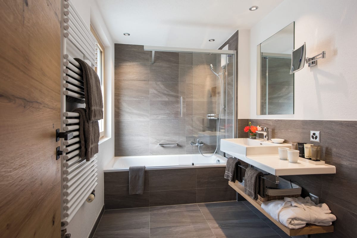 alpine double room (matterhorn view) | bathroom | combined shower/bathtub, free toiletries, hair dryer, slippers