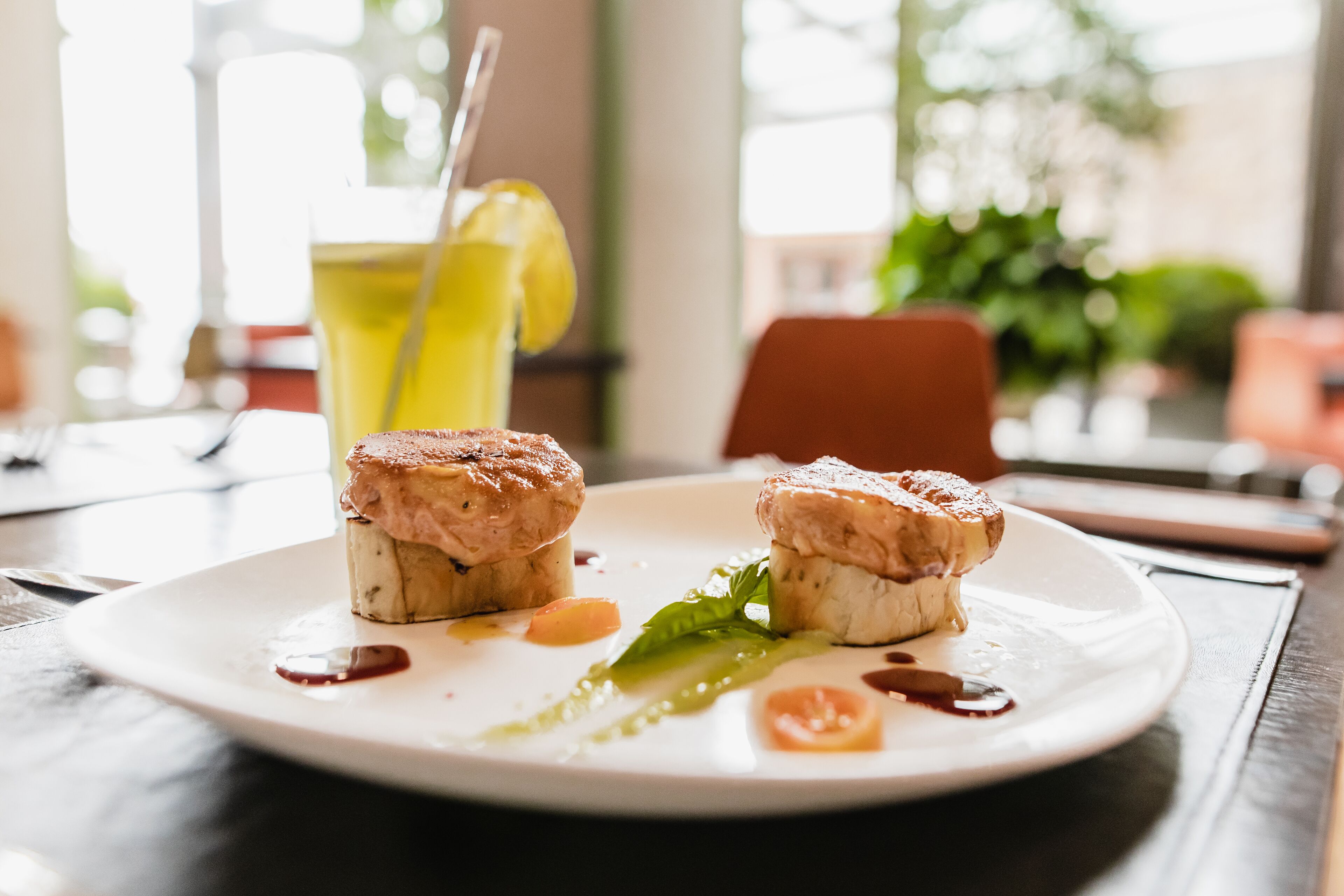 Un plato con dos porciones de comida, una bebida y una servilleta sobre una mesa.