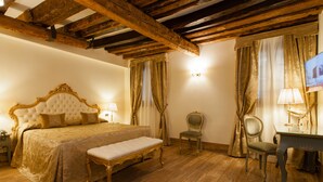 Ein Zimmer mit einem großen Bett, einem Schreibtisch und einem Stuhl.