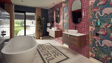 A modern bathroom with a freestanding bathtub, a vanity with a mirror, and a wall with a flamingo-themed tile design.