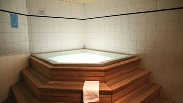 Relax in a serene space with a bathtub and wooden staircase.