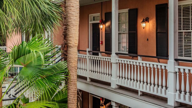A two-story building with a balcony, white balustrade, and black shutters. - Elliott House Inn (Charleston)