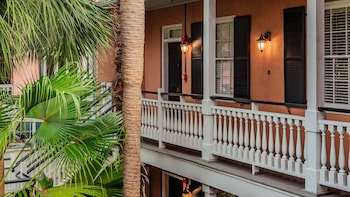 A two-story building with a balcony, a gated entrance, and a street lamp. at Elliott House Inn