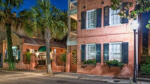 A two-story building with a balcony, a gated entrance, and a street lamp. - Elliott House Inn (Charleston)