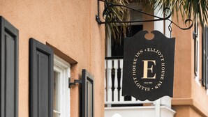 A building with a sign reading "Elliott House Inn" and a black door with a white window. - Elliott House Inn (Charleston)