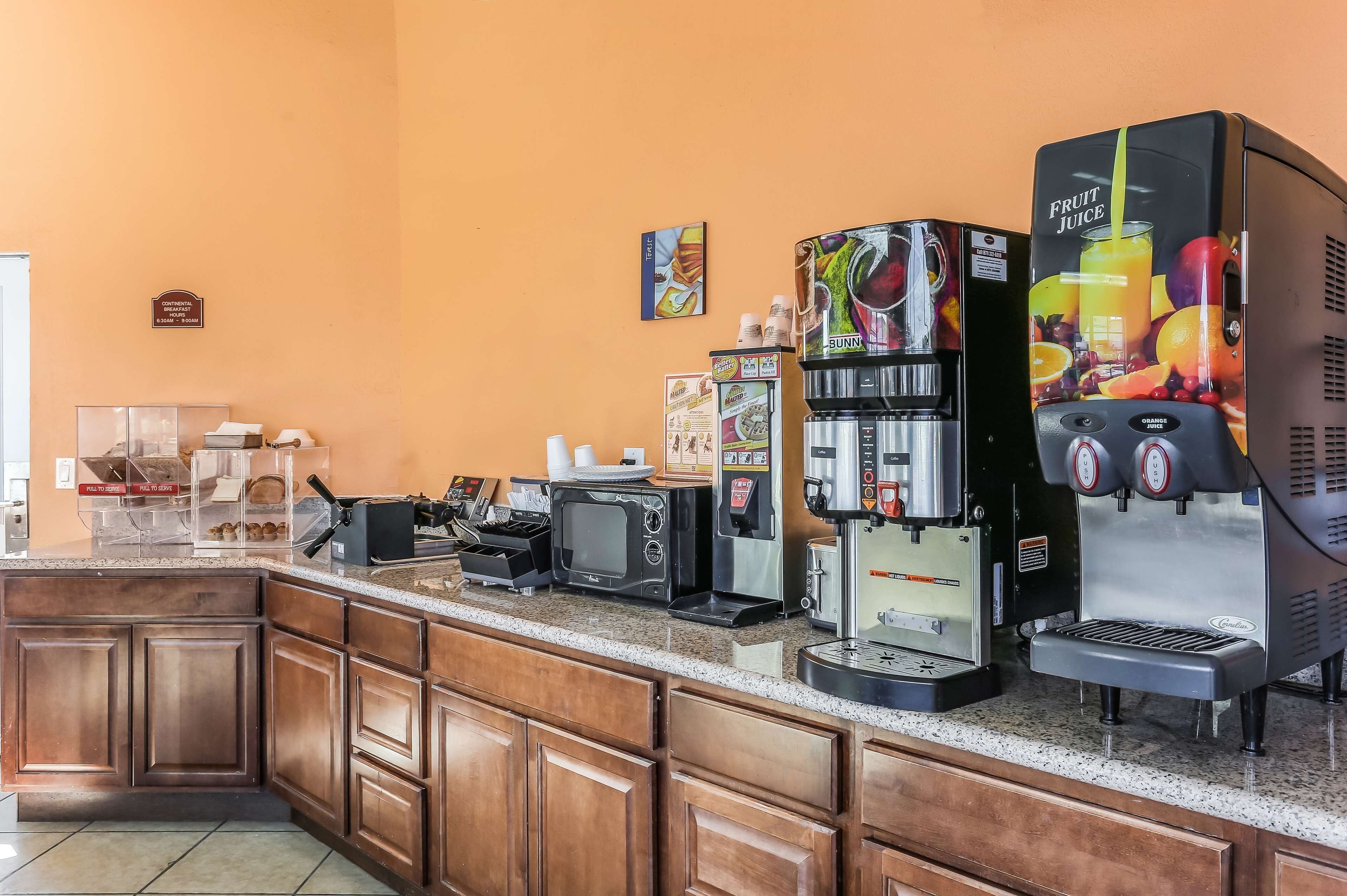 A coffee station with multiple coffee machines and a microwave.