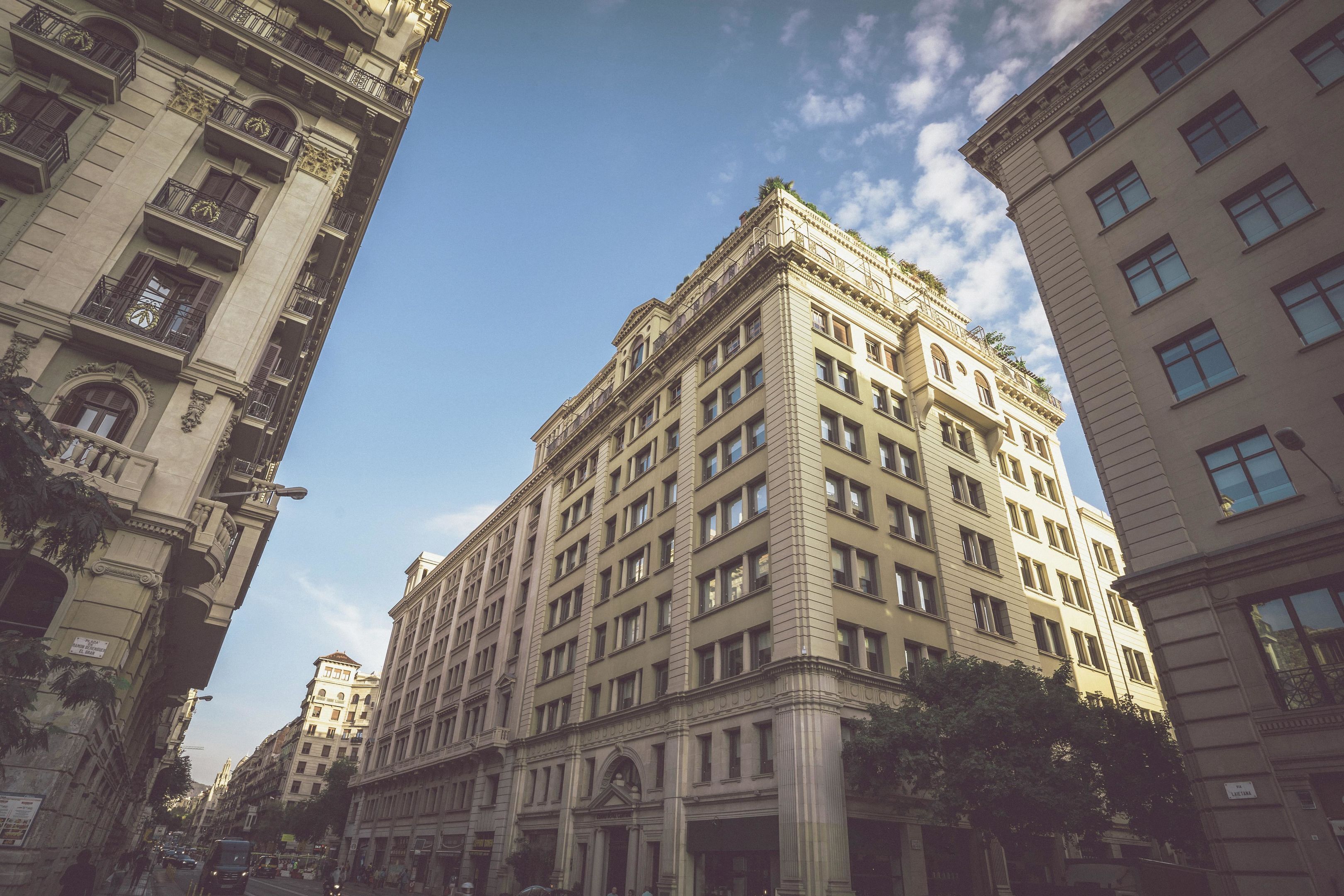 A multi-story building with classical architecture, featuring a central entrance with columns, large windows, and balconies.