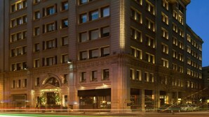 A large, multi-story hotel with a classic architectural style, featuring a prominent entrance and numerous windows. - Grand Hotel Central (Barcelona)