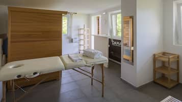 Cozy retreat with a wooden cabinet, shelf unit, and small table, featuring a comfortable bed and a door leading to another area.