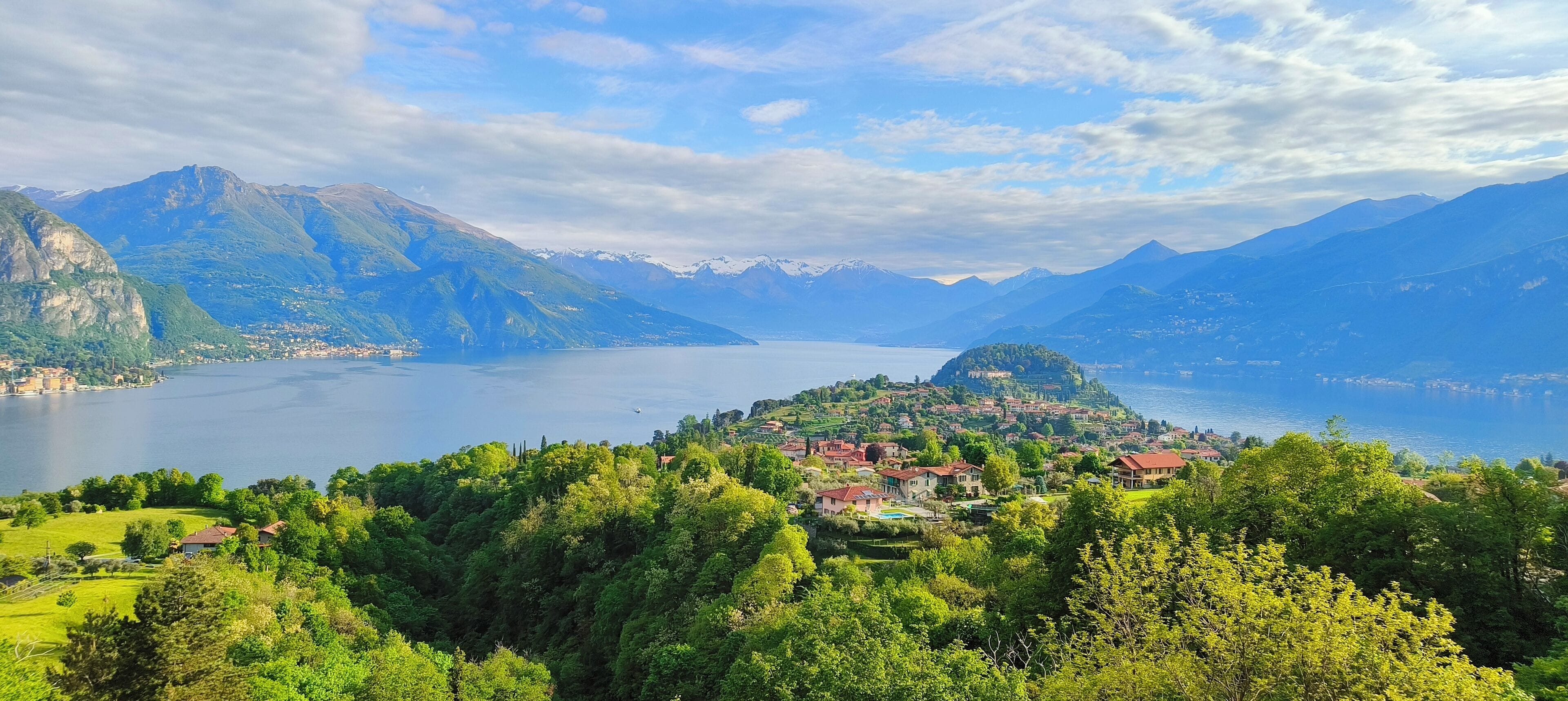 Un paisaje montañoso con un lago y un pequeño pueblo.