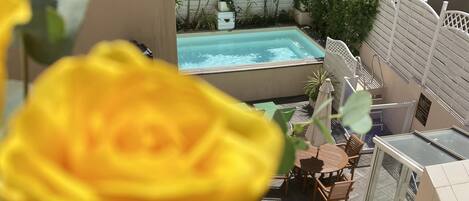 Eine Dachterrasse mit Swimmingpool, Sitzgelegenheiten im Freien und üppiger Bepflanzung.