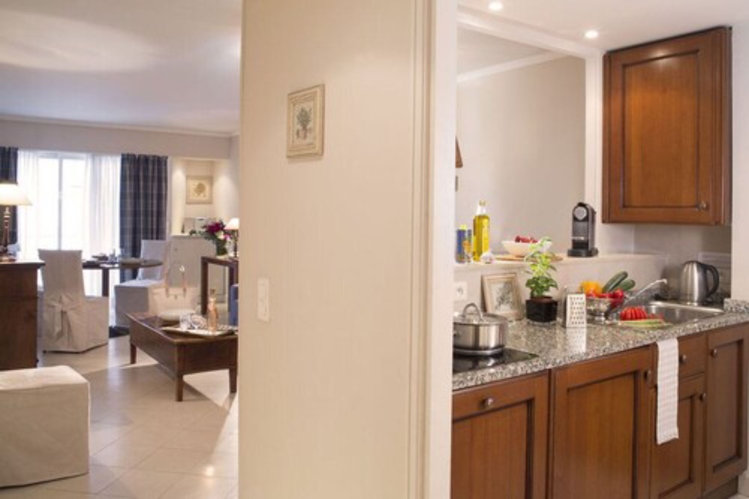 A modern kitchen with granite countertops, wooden cabinets, and a coffee maker.