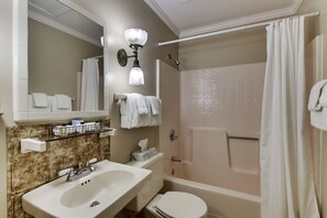 A bathroom with a sink, toilet, bathtub, and a shower curtain.