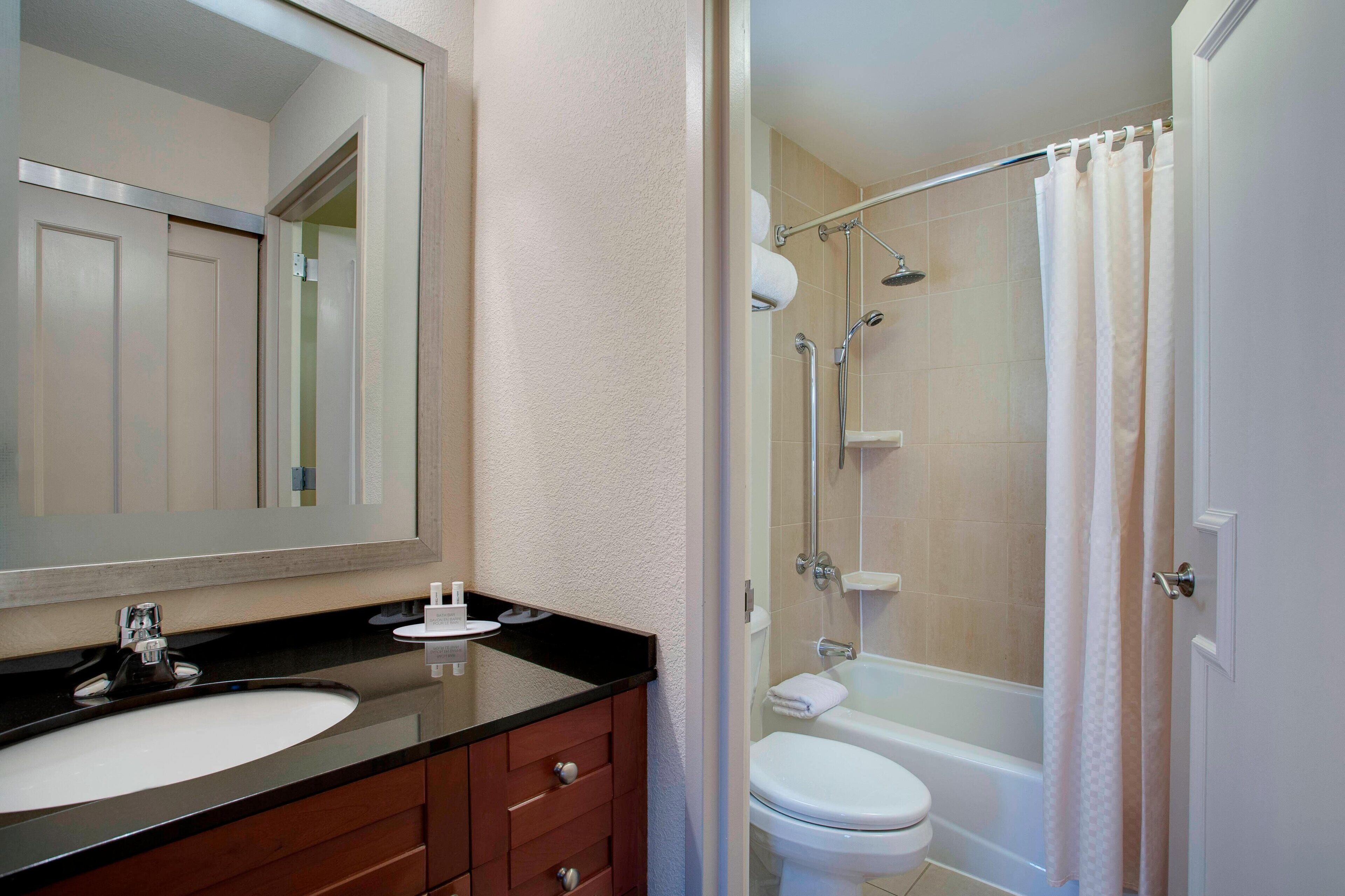 Une salle de bain avec un lavabo, un miroir et une douche.