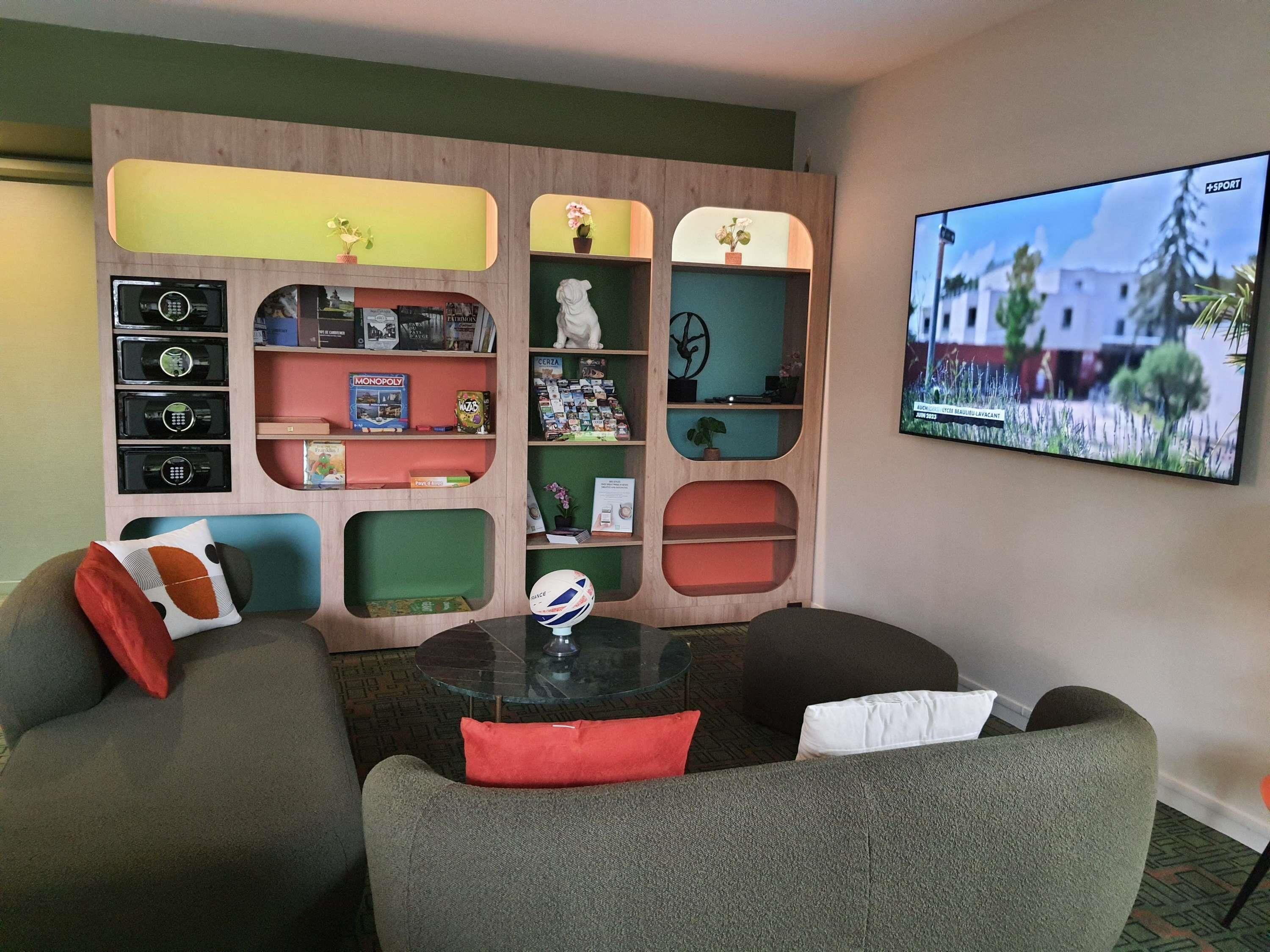 A modern living room with a sectional sofa, a glass coffee table, and a wall-mounted TV.