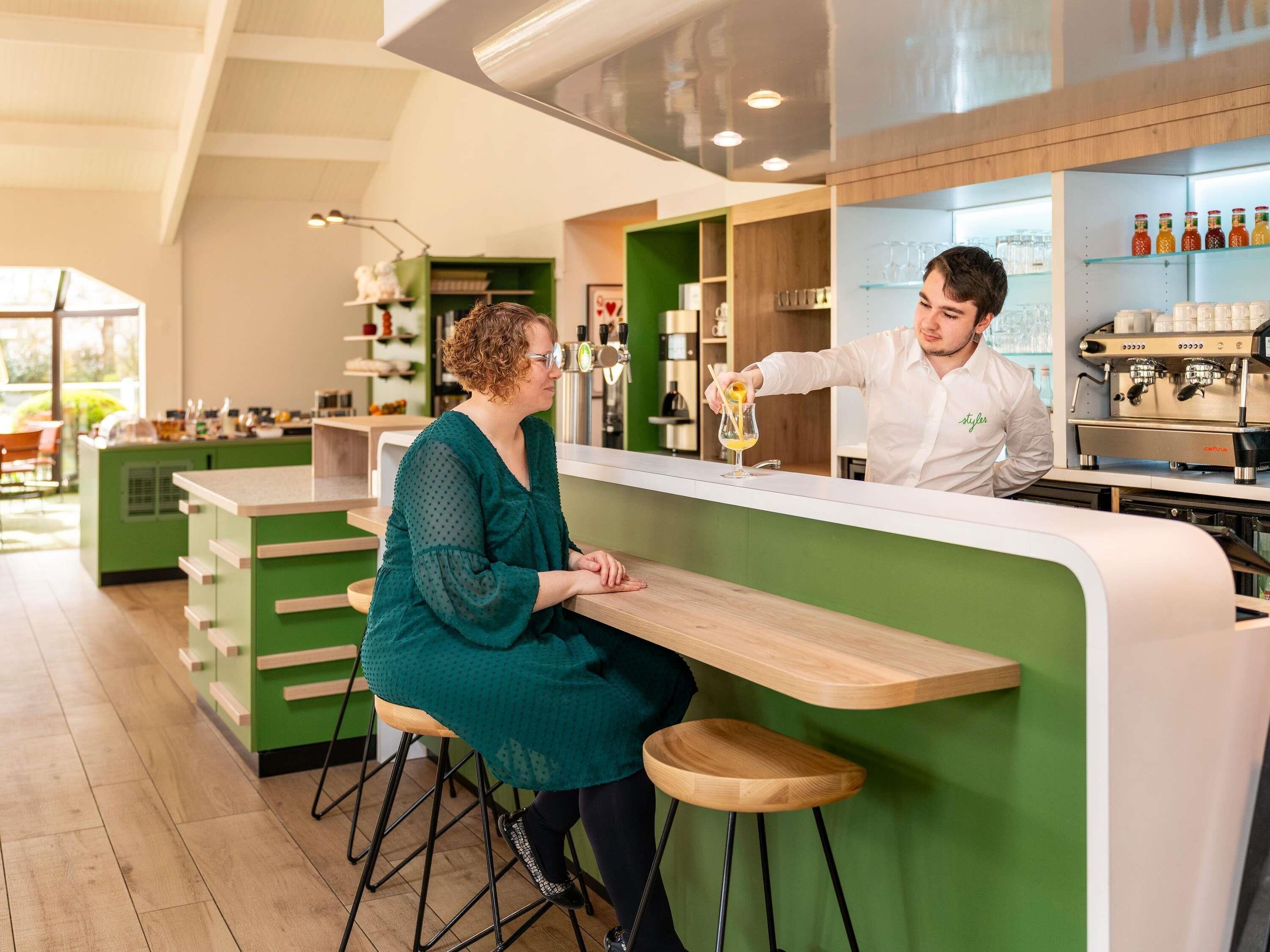 A bar area with stools, a counter, and a coffee machine.
