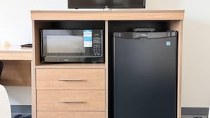 Una kitchenette compacta equipada con microondas y refrigerador.