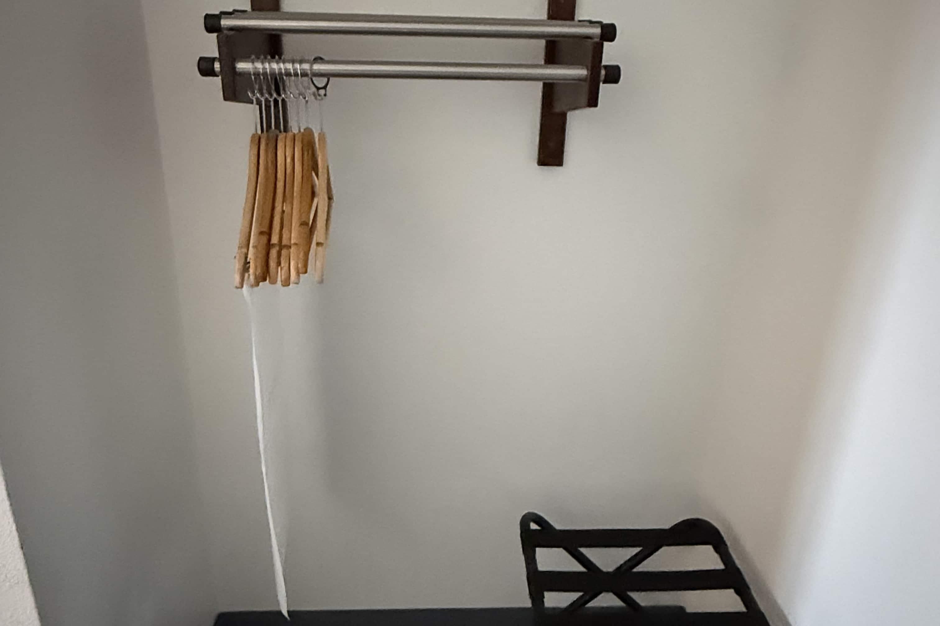 Une pièce avec un portant à vêtements et une petite table.