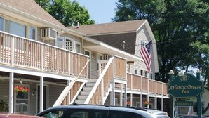 A two-story building with an 'Office' sign, a balcony with a railing, and an American flag. - Atlantic Breeze Inn (Old Orchard Beach)