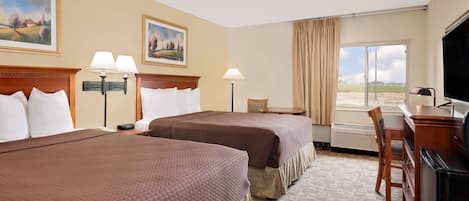 A hotel room with two beds, a desk, a chair, a TV, and a window with curtains.