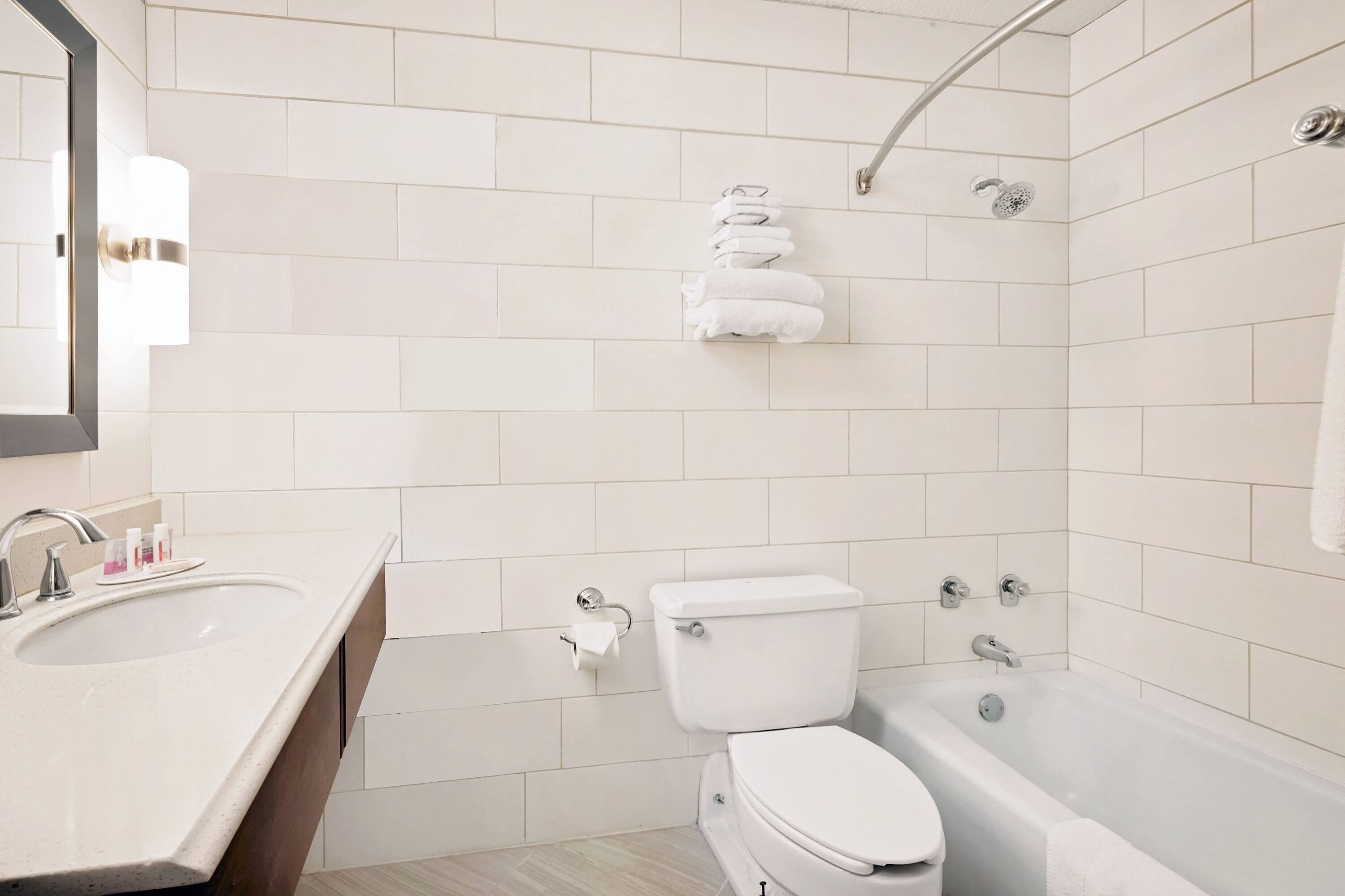 A modern bathroom with a sink, toilet, and bathtub.