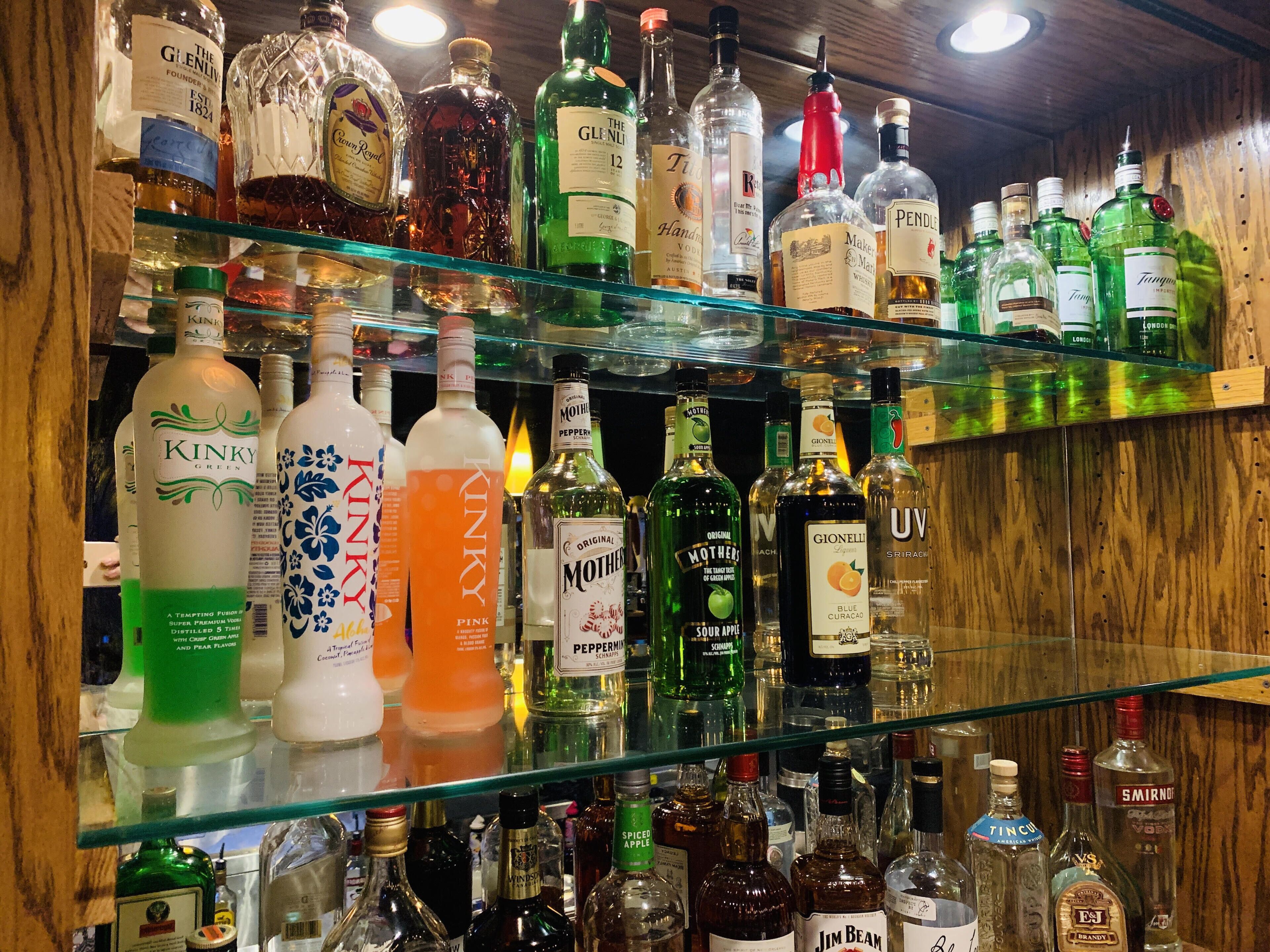 Un bar amb prestatges plens de diverses ampolles de licors.
