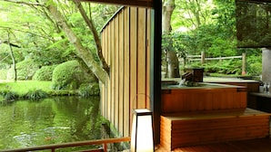 Habitació tradicional japonesa amb terrassa de fusta que donava a un estany, una banca de fusta i un fanal.