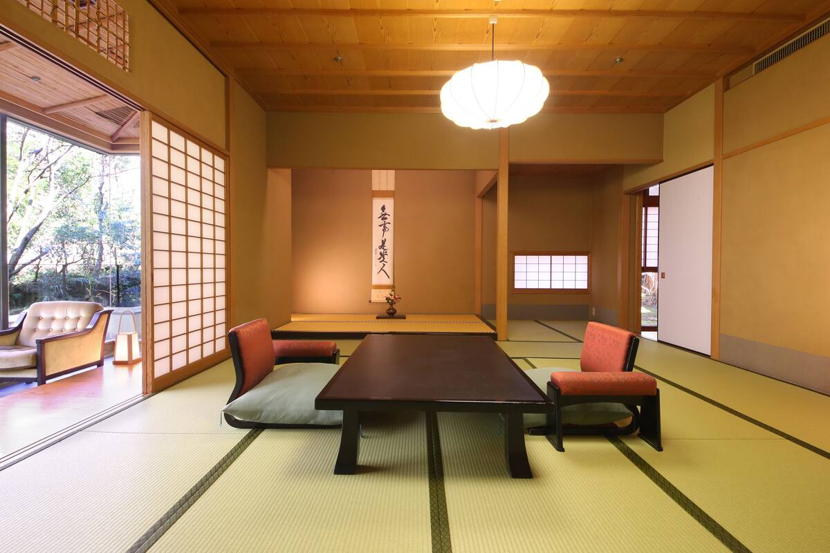 Una habitación japonesa tradicional con suelo de tatami, una mesa baja y cojines.