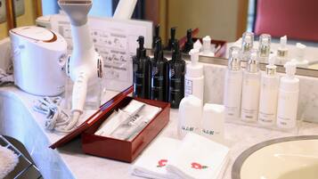 A bathroom vanity with a white sink, a mirror, and various skincare products.