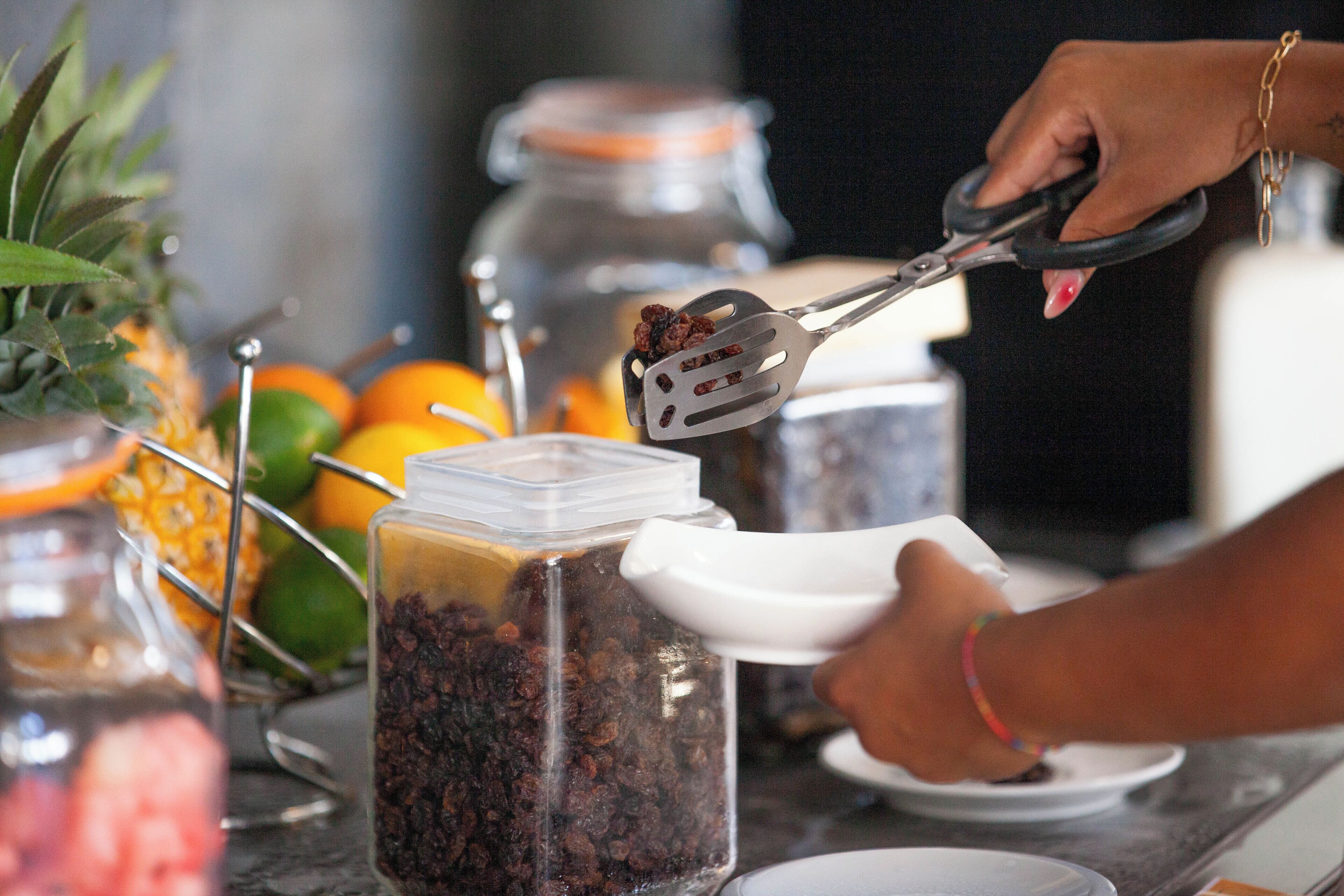 Una persona usando pinzas para manipular alimentos en una cocina.