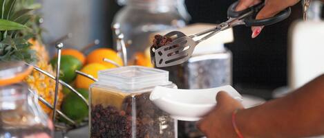 Una persona usando pinzas para manipular alimentos en una cocina.