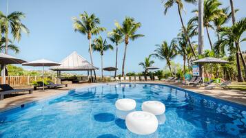 Una piscina al aire libre, sombrillas, sillones reclinables de piscina