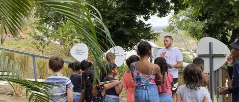 Een groep mensen staat buiten, mogelijk in een park of tuin.
