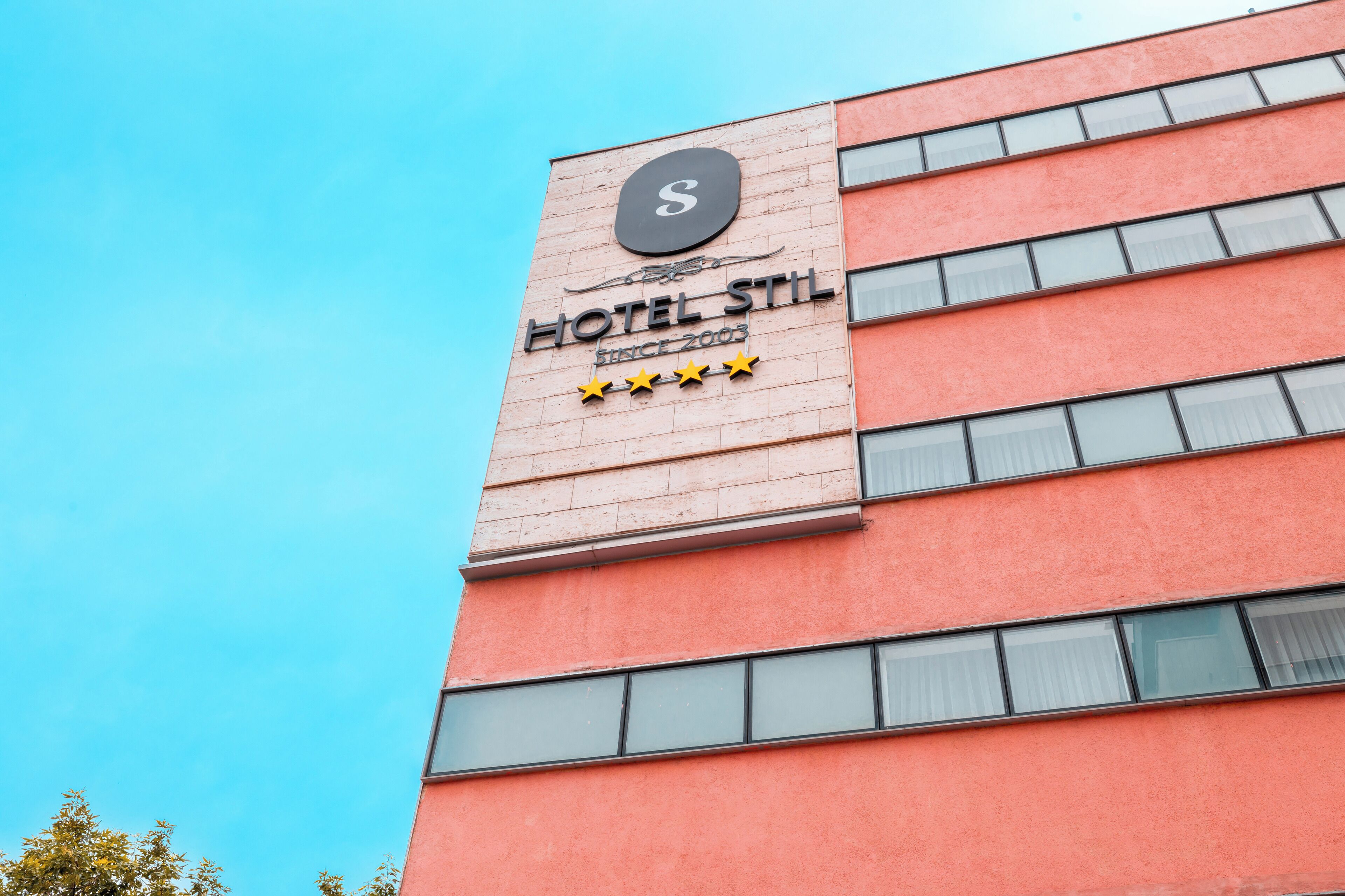 Une enseigne d’hôtel indiquant un établissement cinq étoiles, avec l’inscription « HÔTEL STIL, ÉTABLI EN 2003 ».