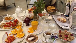 A breakfast table with various dishes, including toast, pastries, and fruit. - Akropolis Hotel (Taranto)