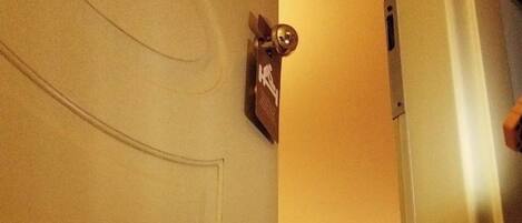 A hotel room with a bed, a nightstand, and a wall-mounted picture.