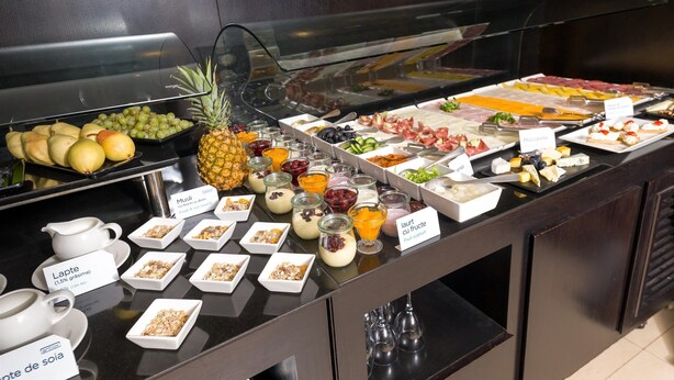 A buffet with various food items including fruits, cheeses, and yogurt. - Hotel CH Bucharest (Bucharest)