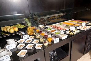 A buffet with various food items including fruits, cheeses, and yogurt.