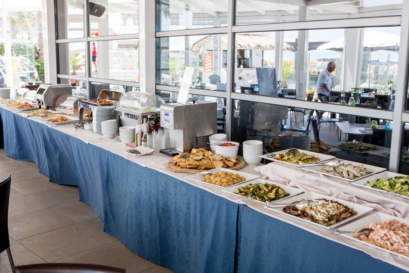Un buffet proposant une variété de plats et d’ustensiles de service.