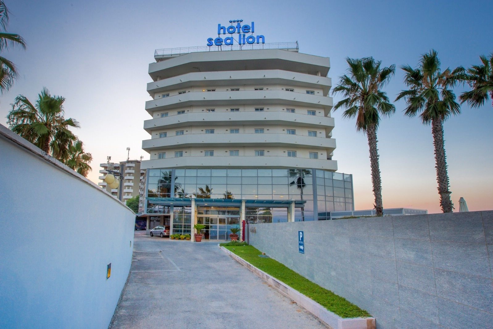 Un hotel de varios pisos con un diseño moderno, que destaca un letrero grande en la parte superior.